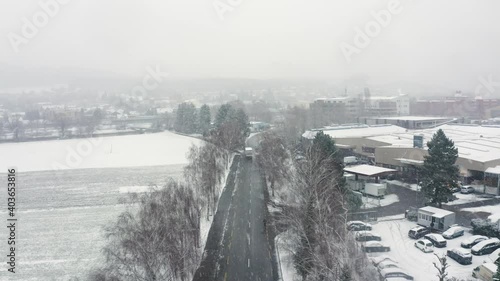 following a truck and a cyclist over a street in a snow blizzard photo