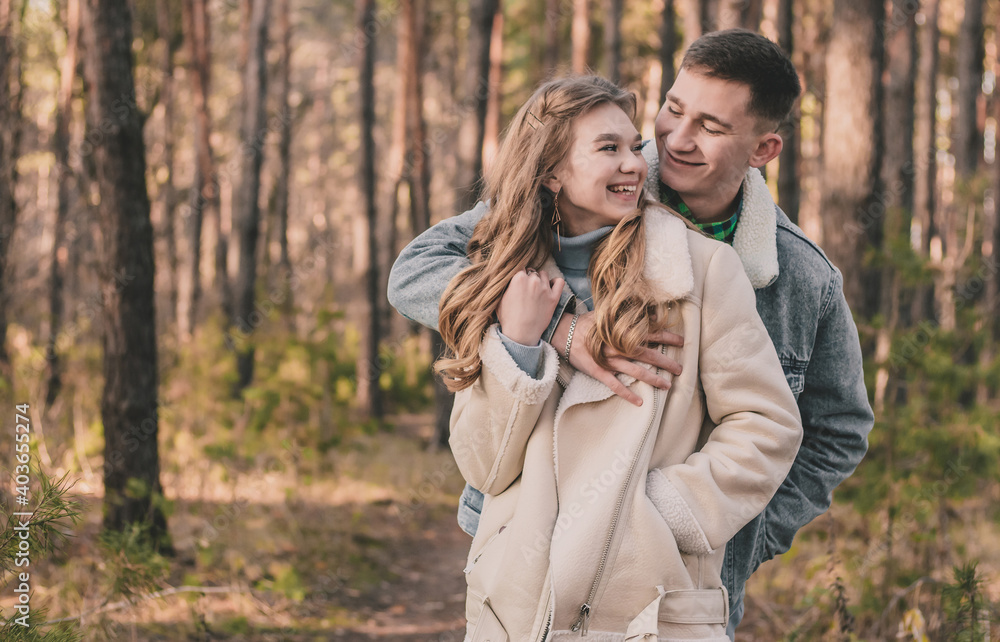 the guy hugs the girl and smiles in the pine forest
the guy hugs the girl and smiles in the pine forest