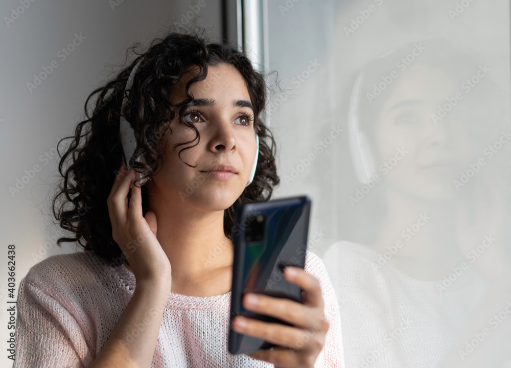 Young woman listening to music with mobile phone