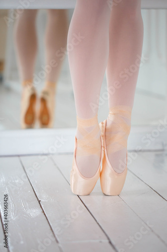 Legs of beauty ballerina standing in pink pointe shoes. Close-up