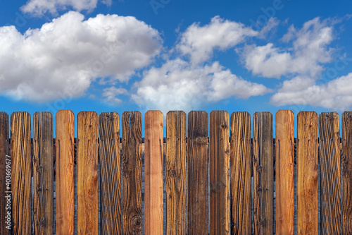 Wooden fence with cloudy blue sky