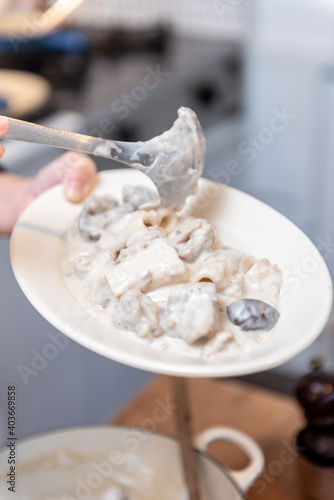 ホワイトソースを使ったフランス料理を皿に盛り付けるシーン