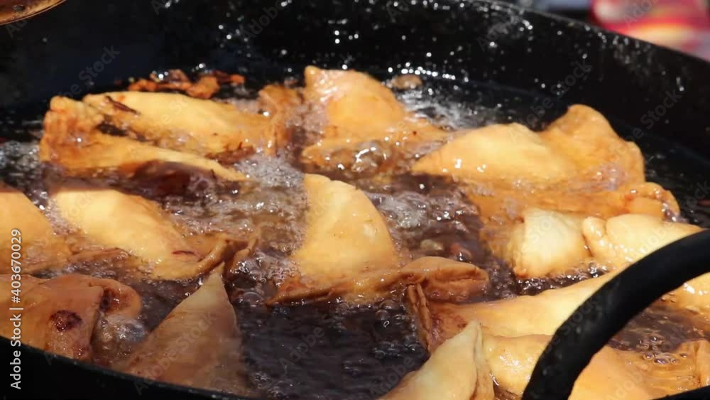 Steering And Turning Of Cooked Golden Brown Samosa Made Of Maida And Stuffed With Mix Of Mashed Potatoes Onions Peas Paneer Or Panir For Masala Chaat In Kadhai Full Of Hot Boiling Oil Steering And Turning Of Cooked Golden Brown Samosa Made Of Maida And Stuffed With Mix Of Mashed Potatoes Onions Peas Paneer Or Panir For Masala Chaat In Kadhai Full Of Hot Boiling Oil