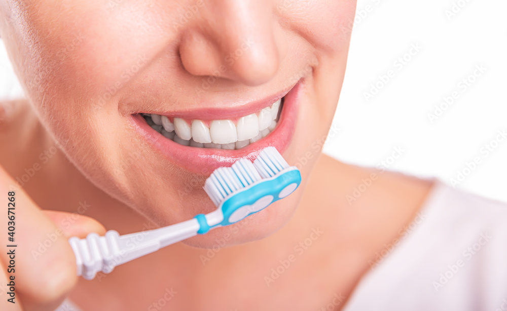 Young woman brushes beautiful white teeth with a toothbrush. Young woman brushes beautiful white teeth with a toothbrush.