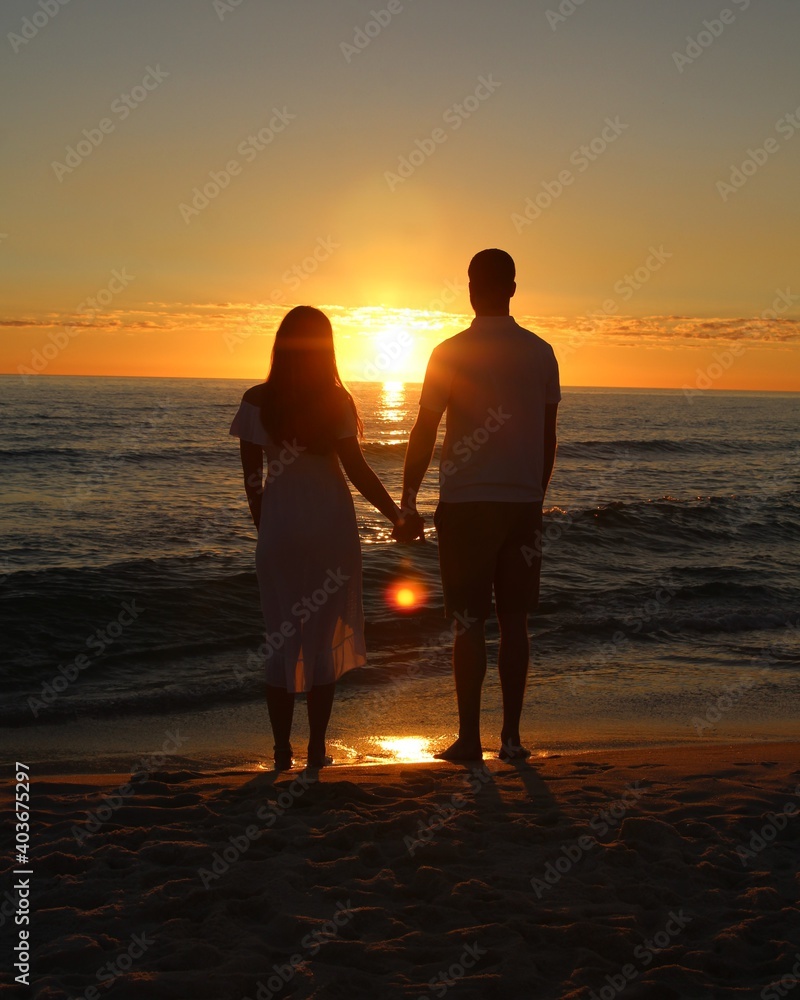 A Young Couple Silhouetted Against a Sunset on Laguna Beach in Panama City Beach, Florida