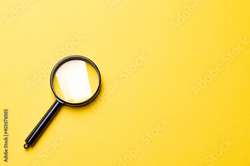 Black magnifier on a yellow background.