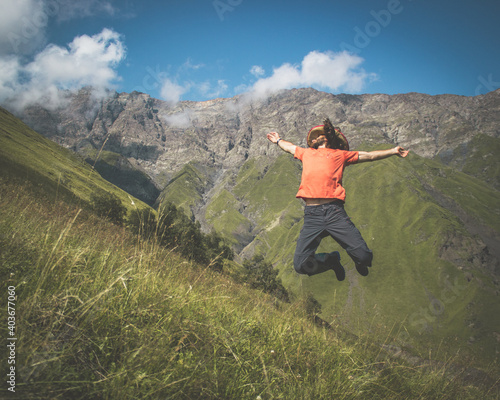 A man jumping on the mountain happily 