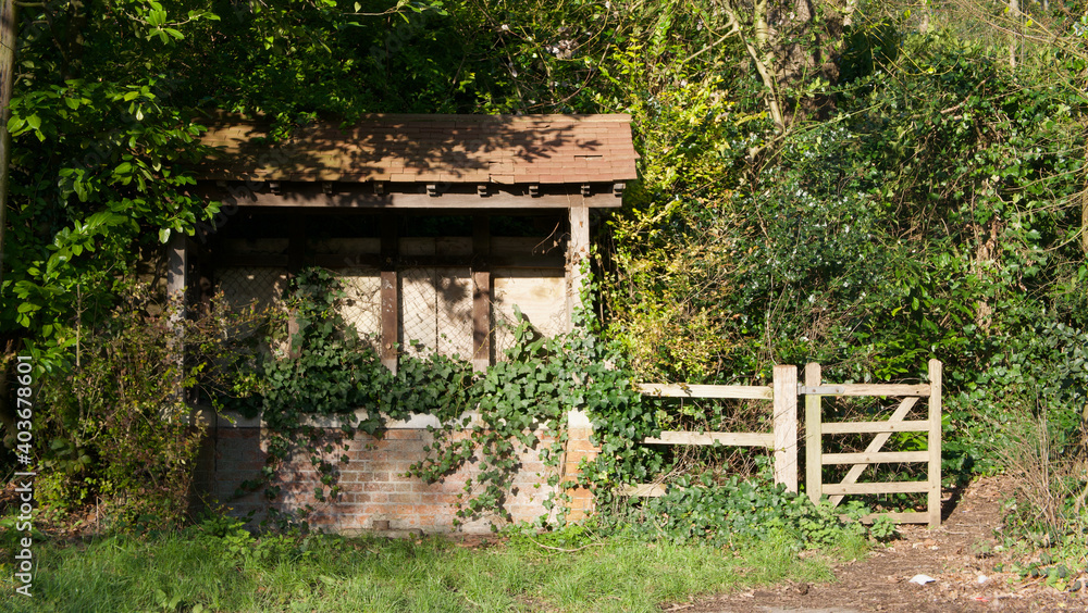 Old dilapidated bus shelter or shack in countryside with gate beside Old dilapidated bus shelter or shack in countryside with gate beside