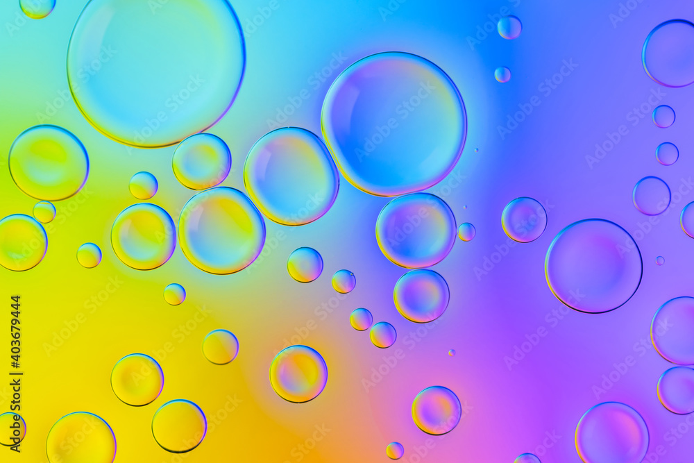 Creative neon background with drops. Glowing abstract backdrop with vibrant gradients on bubbles. Blue, yellow and pink overflowing colors