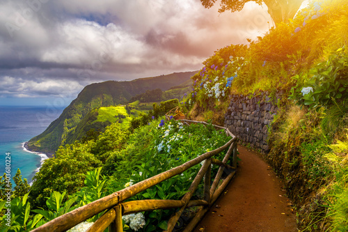 Viewpoint Ponta do Sossego, Sao Miguel Island, Azores, Portugal. View of flowers on a mountain and the ocean in Miradouro da Ponta do Sossego Nordeste, Sao Miguel, Azores, Portugal. photo