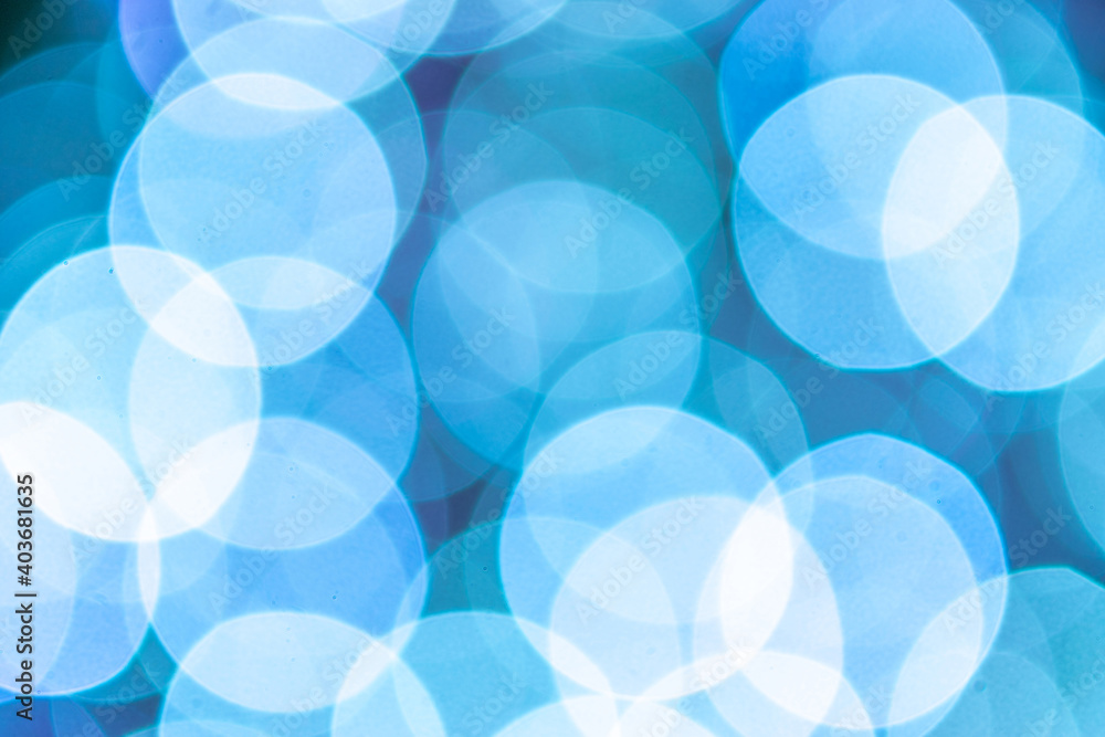 Blue bokeh lights. Abstract glitter festive blur background. Christmas and New Year holidays backdrop.
