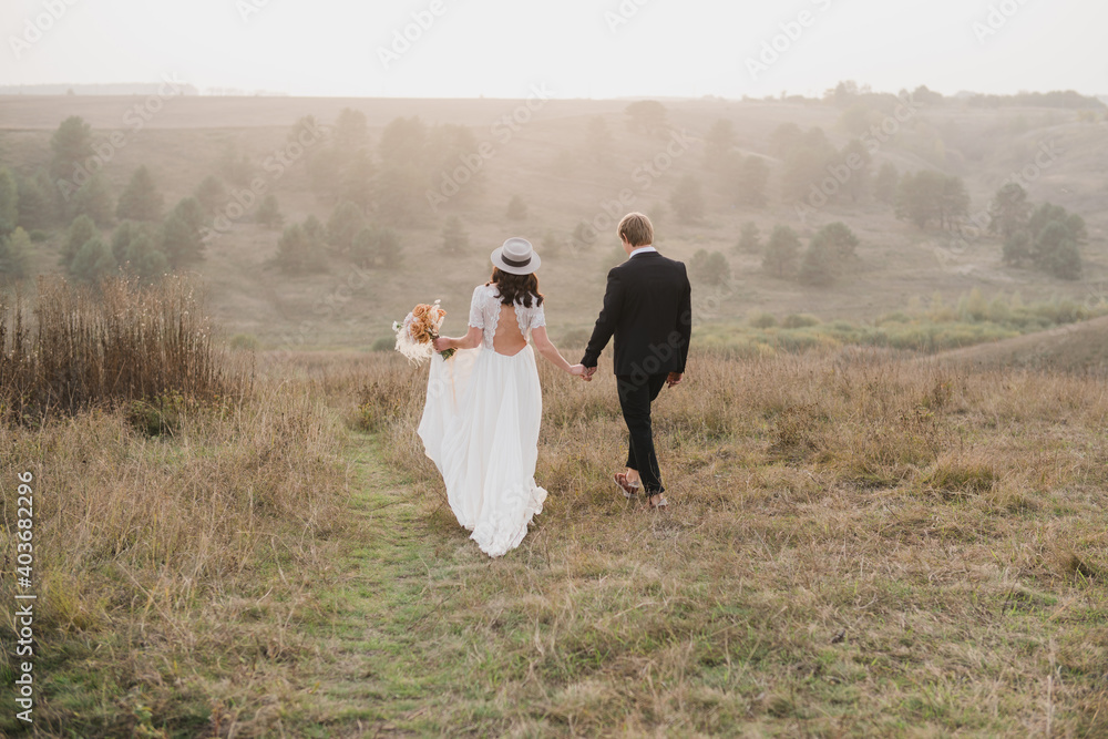 Romantic, young and happy caucasian couple in wedding clothes on the background of beautiful nature. Love, relationships, romance, happiness concept. Bride and groom traveling together. Romantic, young and happy caucasian couple in wedding clothes on the background of beautiful nature. Love, relationships, romance, happiness concept. Bride and groom traveling together.