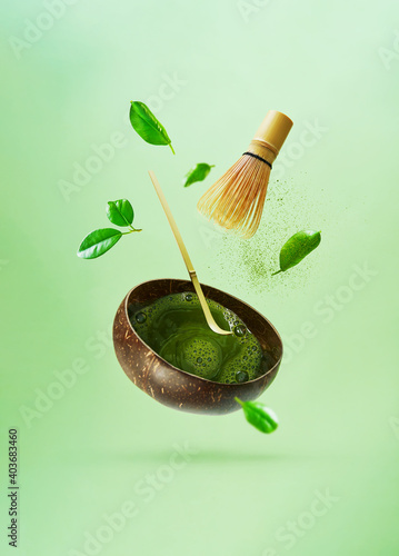 The concept of levitation of making matcha green tea. Flying tea leaves, matcha powder, bamboo whisk, spoon.