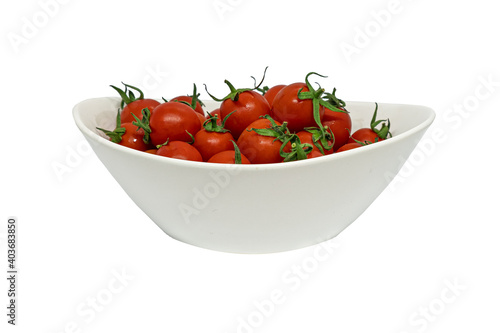 fresh organic cherry tomatoes with green leaves in plate isolated on white