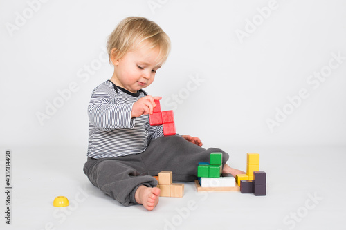 Wallpaper Mural Little baby boy is playing with colourfull wooden block isolated on white background. Education and learn game concept with copy space. Torontodigital.ca