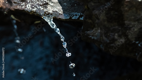 Silver Stream of Water Pouring from a Rock