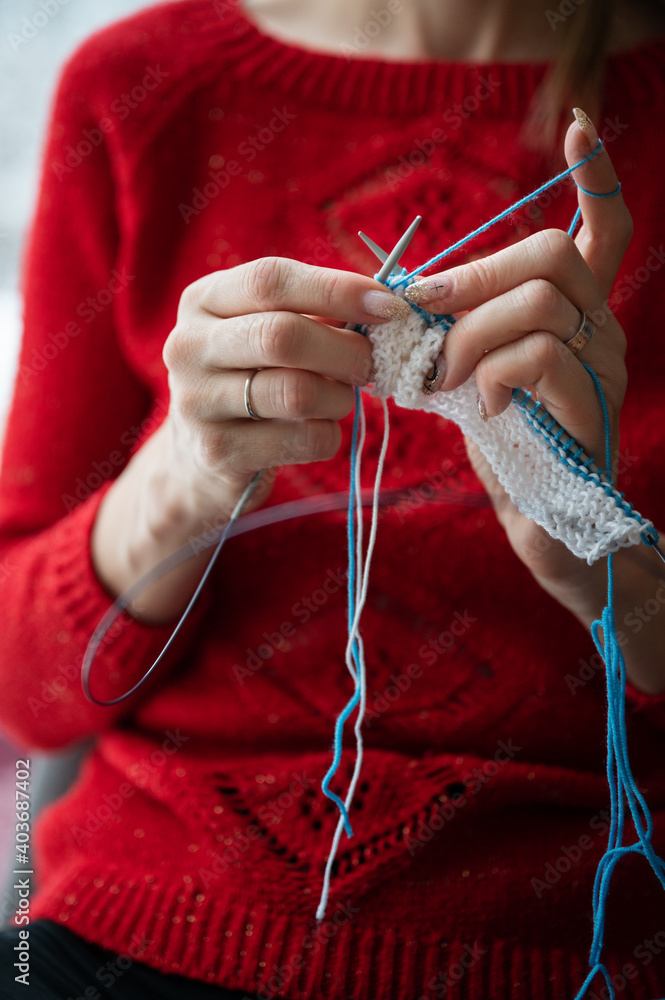 Closeup view of a woman knitting a scarf