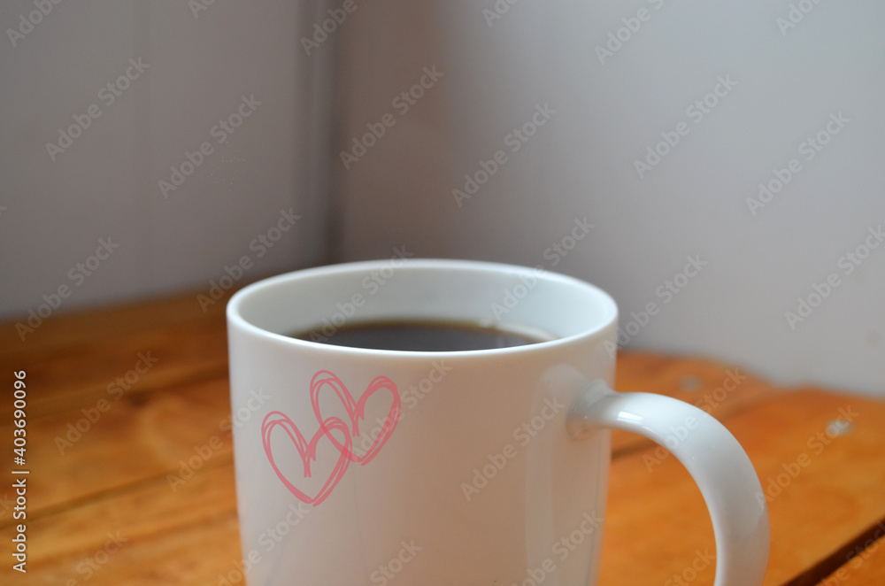 White cup with coffee on a wooden background. White cup with coffee on a wooden background.