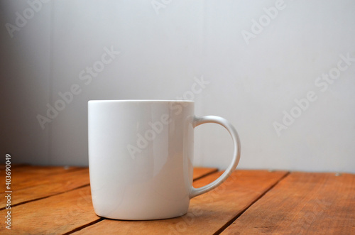 White cup with coffee on a wooden background.
