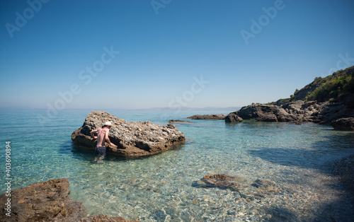Man is climbing on the rock in the sea