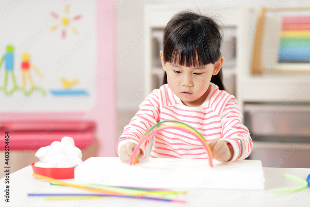 young girl making rainbow craft using pipe cleaner at home young girl making rainbow craft using pipe cleaner at home