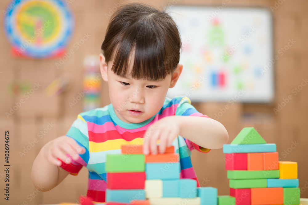 Fototapeta premium young girl playing creative toy blocks for homeschooling