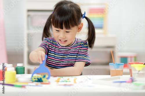 young girl decorating hand made craft for homeschooling