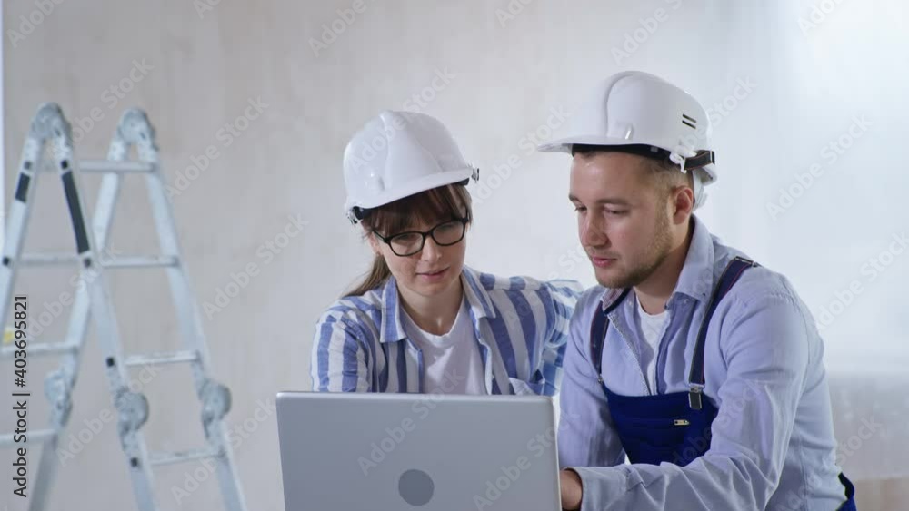 working team, young friendly specialists designers builders male and female with color scheme in their hands discussing new modern renovation for room using project on laptop working team, young friendly specialists designers builders male and female with color scheme in their hands discussing new modern renovation for room using project on laptop