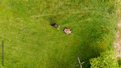 Fotografie, Obraz Drop down view of a person mowing lawn.