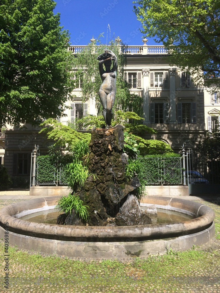 Italy, fountain in the green garden: statue of a naked woman