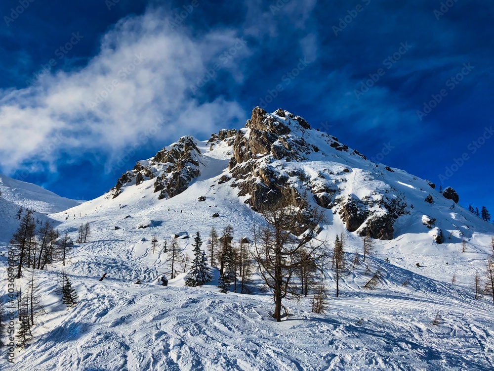 Snowy Rocky Mountain in Nassfeld Ski Center in Austria. Blue Sky and Winter Scenery.