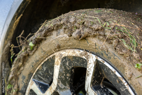 Close up of dirty off road car wheels with dirty tires covered with yellow mud.