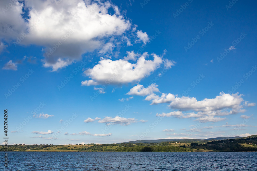 View from a boat of Vlasina lake with clouds on the blue sky