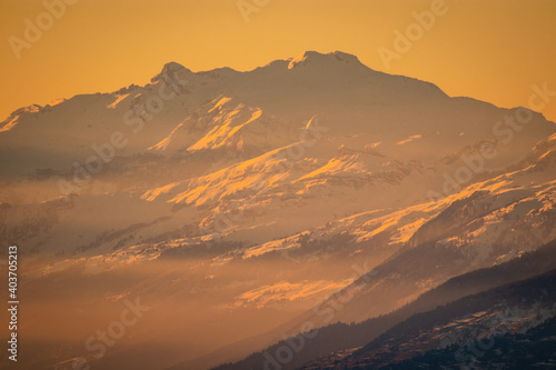 Winter setting in swiss alps above the valley of Brig, viewed from the Simplon pass in early evening at sunset