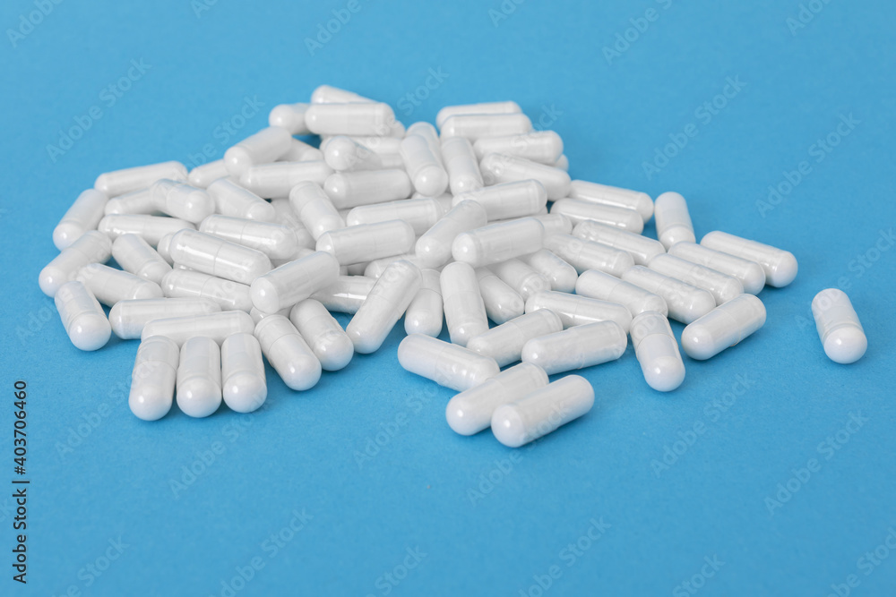 White pills on the blue paper background
White pills on the blue paper background