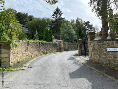 Looking up, Thwaites Brow Road, with high stone walls, and trees in, Thwaites, Keighley, UK