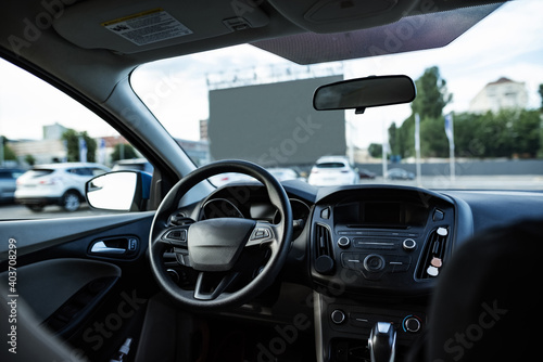 Autocinema screen viewed through front window of empty car © Svitlana