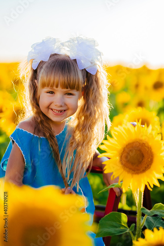 Little girl rejoices in the sunflower field