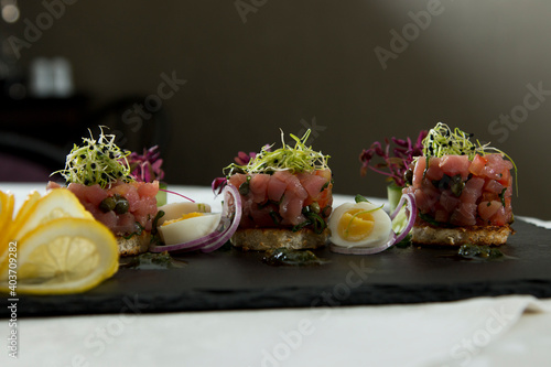 Tuna tartar with wheat germ on black slate photo