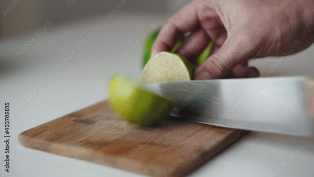 Chico Latino corta un limon en una tabla de madera en la cocina. Chico Latino corta un limon en una tabla de madera en la cocina.