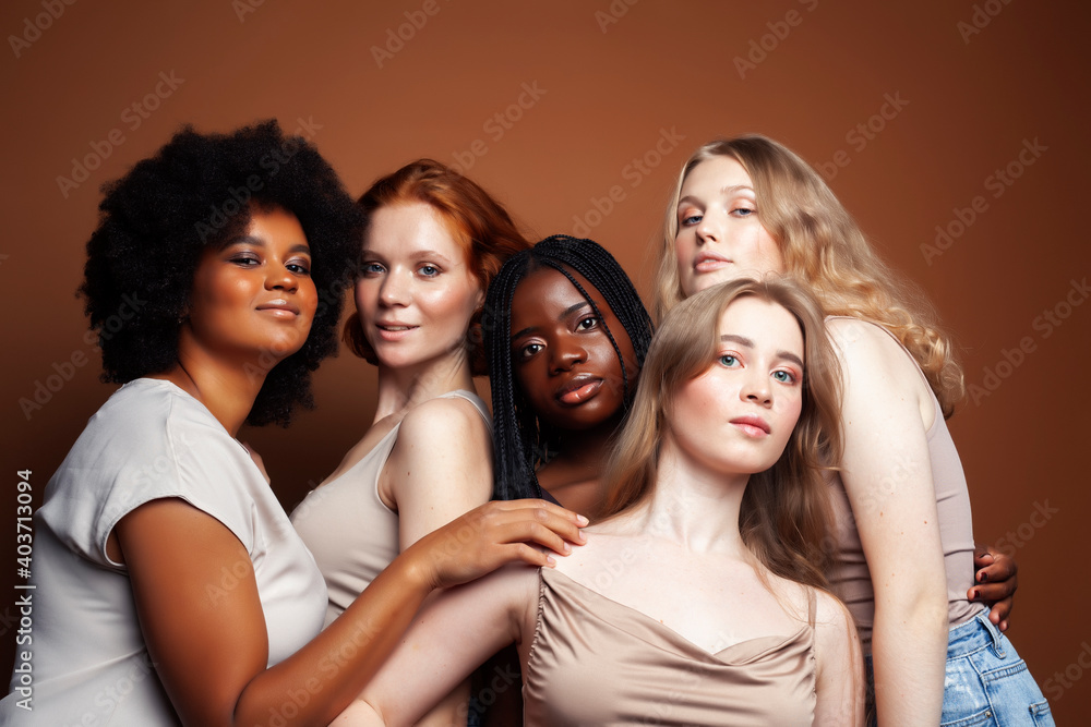 Obraz premium young pretty caucasian, afro, scandinavian woman posing cheerful together on brown background, lifestyle diverse nationality people concept