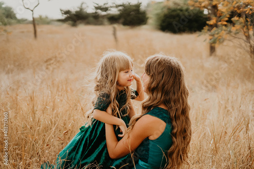 Mom hugs and laughs with her daughter in nature