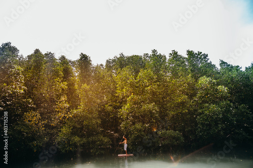 Man paddling standing on a wooden raft