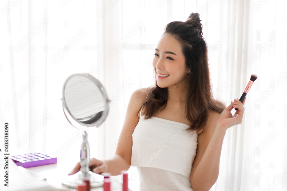 Smiling of young beautiful pretty woman clean fresh healthy white skin looking at camara.girl holding make-up brushes and make up on face with cosmetics set at home.facial beauty and cosmetic concept Smiling of young beautiful pretty woman clean fresh healthy white skin looking at camara.girl holding make-up brushes and make up on face with cosmetics set at home.facial beauty and cosmetic concept