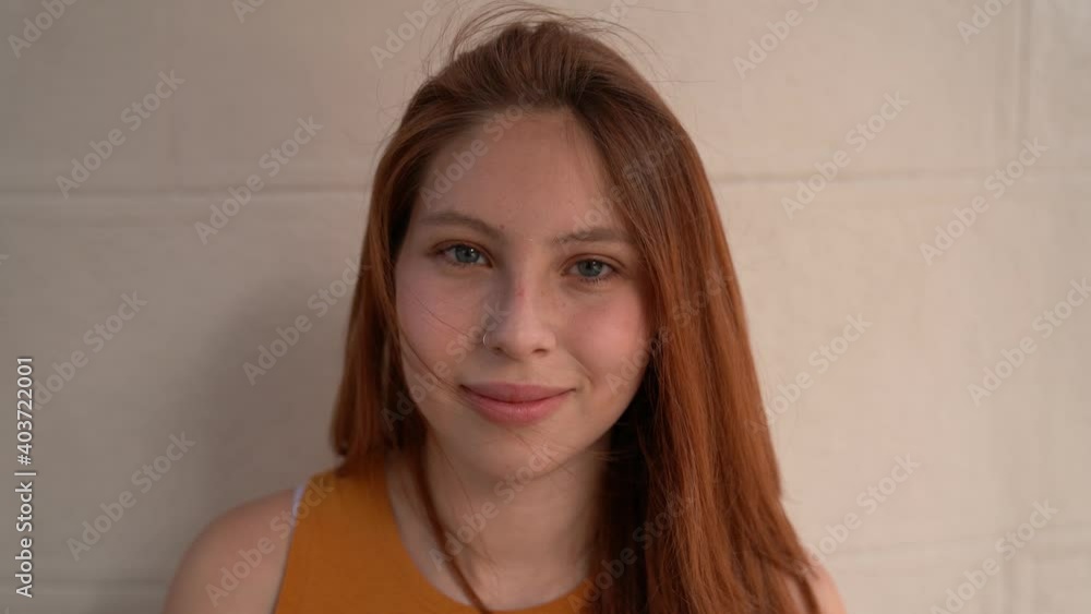 a beautiful white redhead latina woman shows her charming smile as her hair rises in the wind a beautiful white redhead latina woman shows her charming smile as her hair rises in the wind