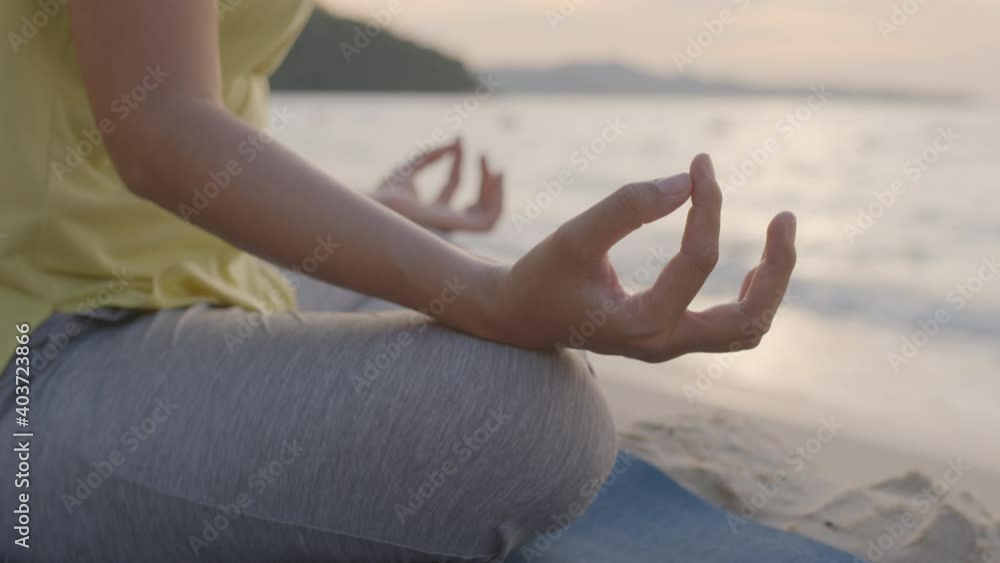 Hand of woman Practicing yoga on a beach in summer sunrise or sunset outdoor Hand of woman Practicing yoga on a beach in summer sunrise or sunset outdoor
