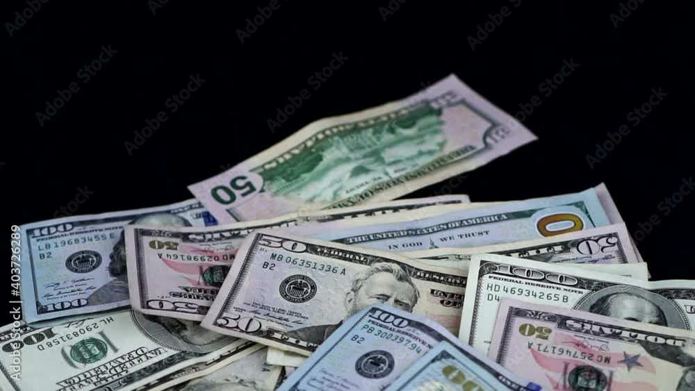 Banknotes In Hundred And 50 Dollar Denomination Falling Against Black Background - studio shot Banknotes In Hundred And 50 Dollar Denomination Falling Against Black Background - studio shot