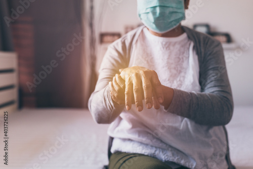 Elderly woman suffering with parkinson's disease symptoms on hand