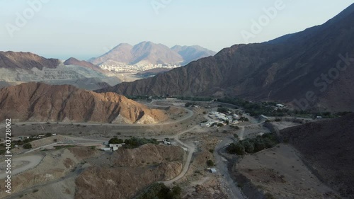 UAE MOUNTAINS:  Top View of Khorfakkan village and mountains, a traditional northern town between the hills. 4k Footage photo