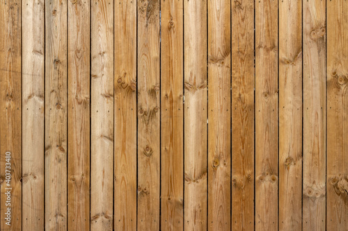 Full frame texture background of a wooden fence with natural wood grain planks, in bright sunlight photo